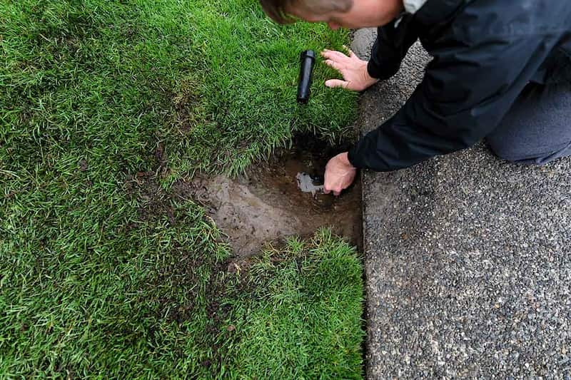 man installing a sprinkler head for irrigation